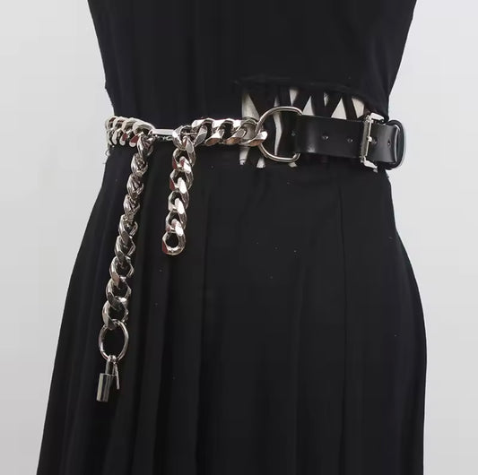 Black dress with a chain belt and spiked details on a white background