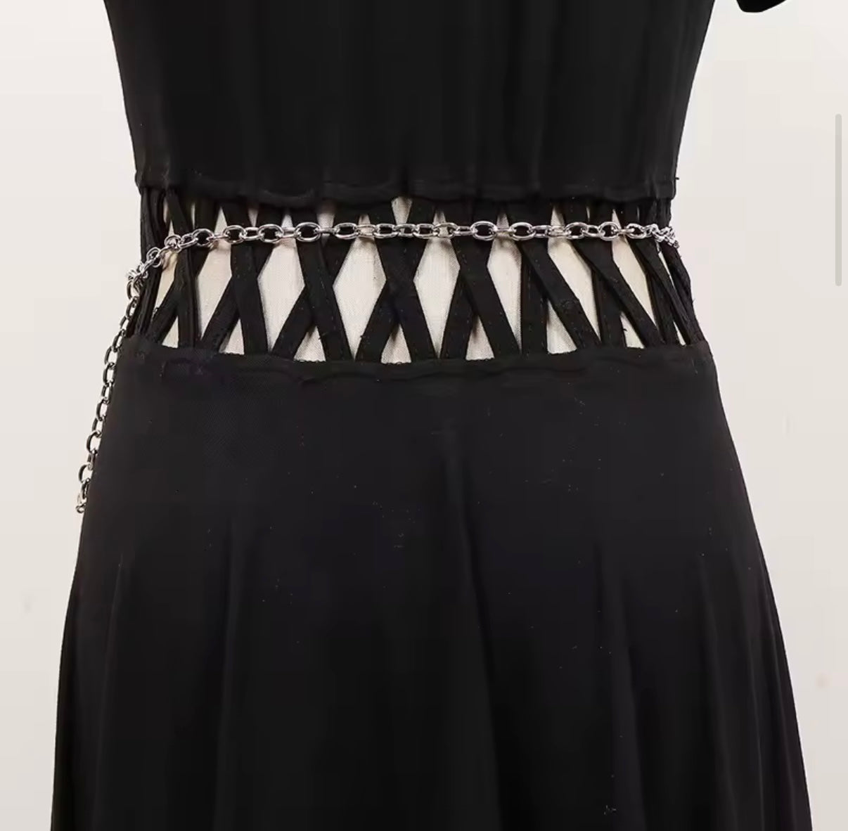 Black dress with a unique belt design on a white background
