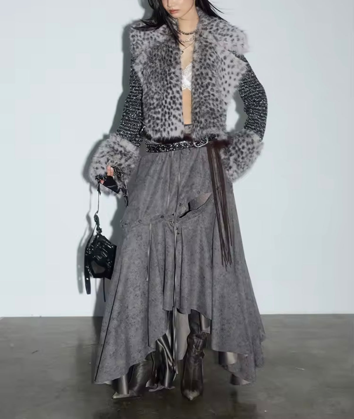 Person wearing a stylish outfit with a leopard print vest and skirt on a plain background