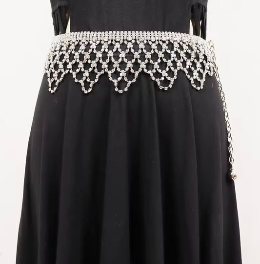 Black dress with a decorative white beaded waistband on a white background