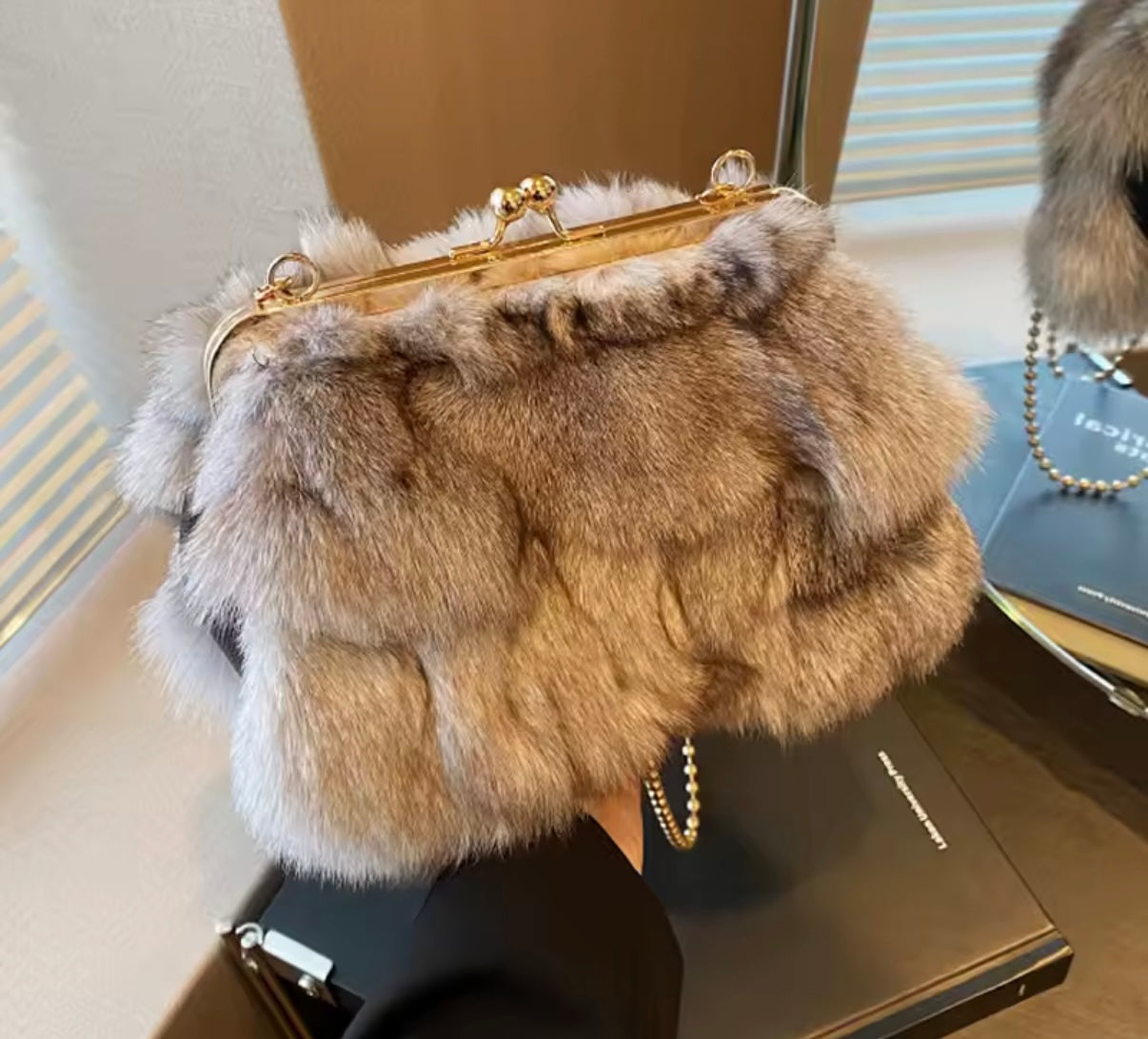Furry handbag with gold frame on a surface